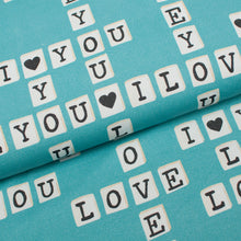 Tissu en ligne Québec jersey de coton lycra motif de Saint-Valentin avec mot de scrabble. Online fabric cotton spandex jersey knit with scrabble print.