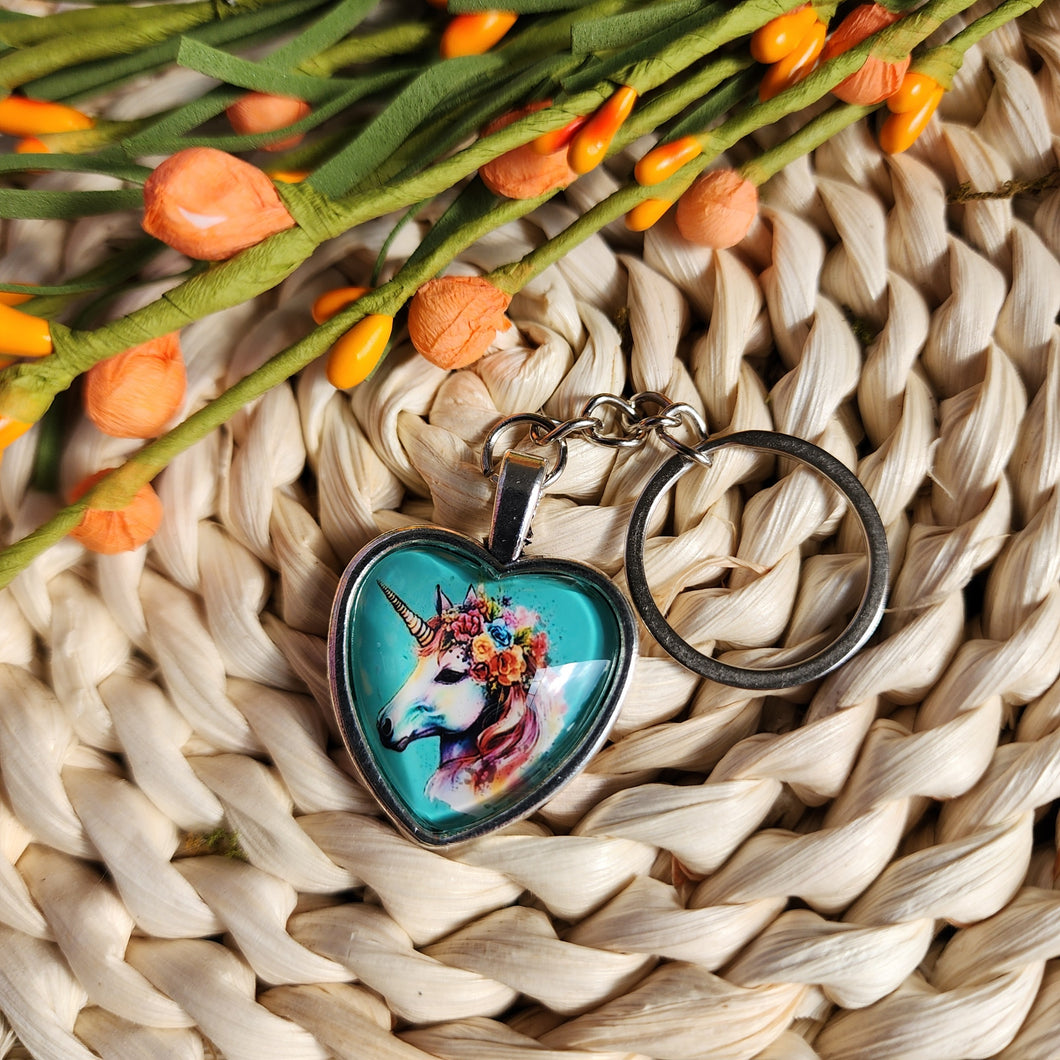 Porte-clés cabochon avec motif d'une licorne avec des fleurs. Cabochon key ring with a unicorn and flowers. Forme de coeur.