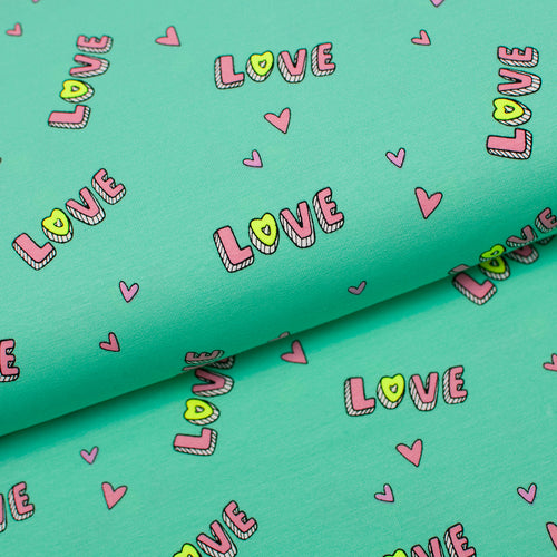 Tissu en ligne Québec jersey de coton lycra motif de coeur avec love. Online fabric cotton spandex jersey knit with heart and love.