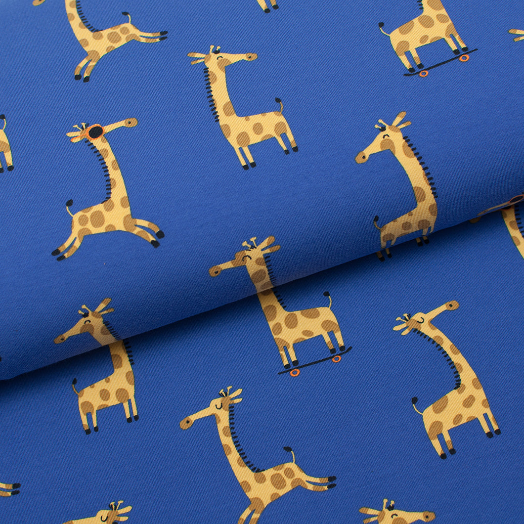 Tissu en ligne Québec jersey de coton lycra motif de girafe sur une planche à roulettes. Online fabric jersey cotton spandex knit with giraffes on skaboard.