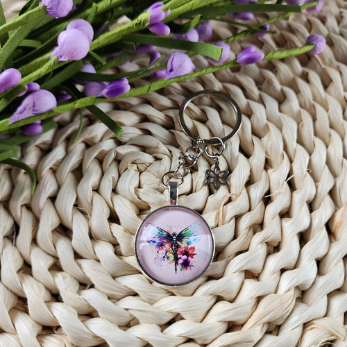 Porte-clés cabochon avec motif de libellule avec des fleurs. Cabochon key ring with a dragonfly and flowers.